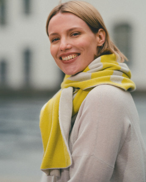 Woman wearing a yellow and gray scarf with a blurred background
