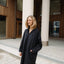 Woman in a black coat standing in front of a building with columns