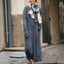 Woman wearing a long gray dress with a scarf in an urban setting