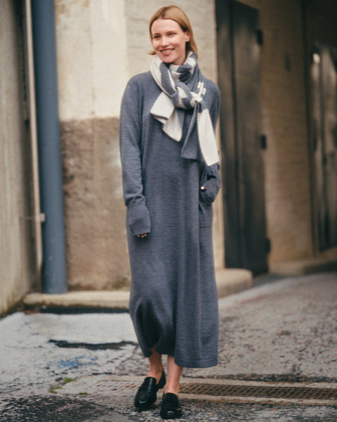 Woman wearing a long gray dress with a scarf in an urban setting