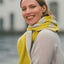 Woman wearing a yellow and gray scarf with a blurred background