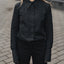 Person wearing a black outfit standing on a paved surface